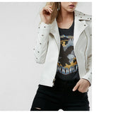 Woman wearing a white leather biker jacket with golden studs and an asymmetrical zipper.