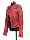 Woman wearing a red leather biker jacket heavily embellished with dark gunmetal studs and spikes.